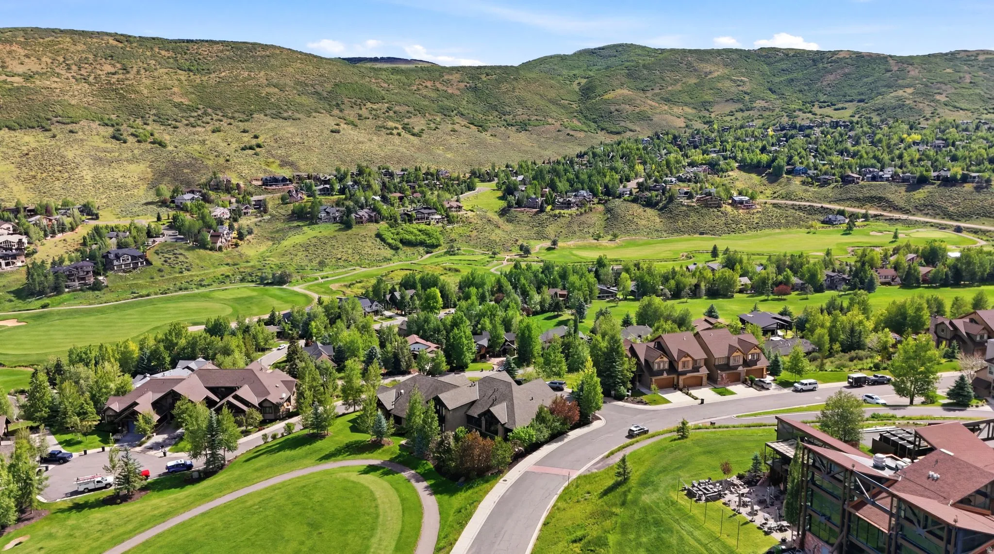 Expansive green spaces define this community, featuring a manicured golf course, mature trees, and mountainous terrain