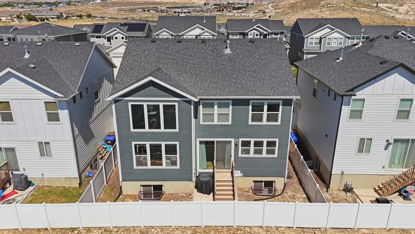Contemporary residential architecture featuring a dark gray shingle roof, blue-gray vertical siding, and multiple large windows