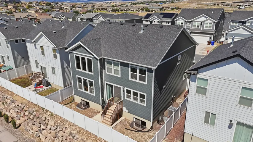 Contemporary two-story residence featuring dark gray siding and a matching shingle roof