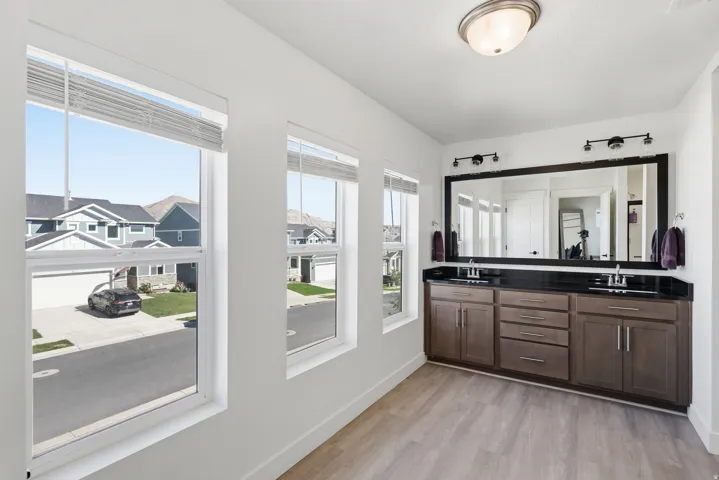 Bathroom featuring a dual vanity with a dark countertop and undermount sinks