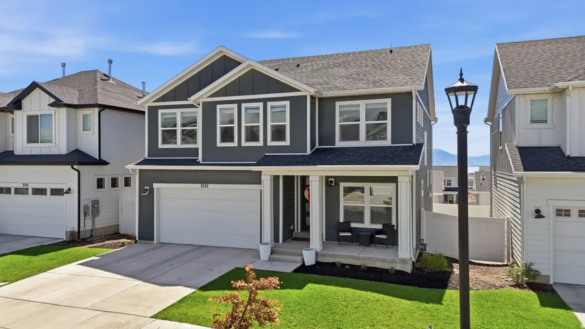Two-story residence featuring a dark gray exterior with white trim accents and a covered front porch