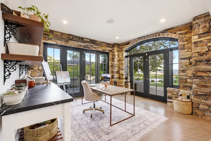Stone accent walls and a tongue-and-groove ceiling frame this versatile room