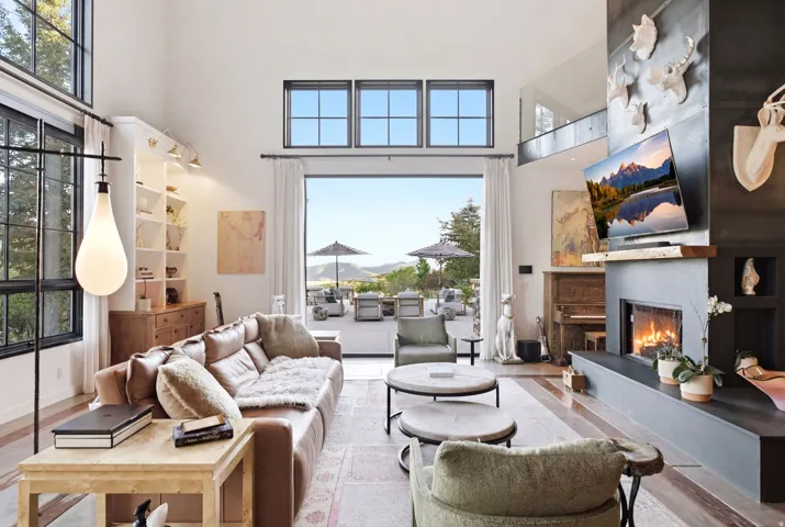 Spacious living area featuring high ceilings and expansive glass doors opening to an outdoor patio