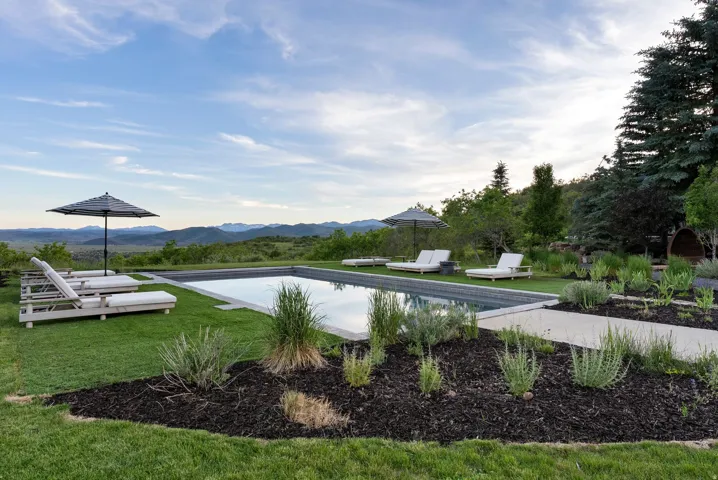Rectangular inground swimming pool set within a manicured lawn