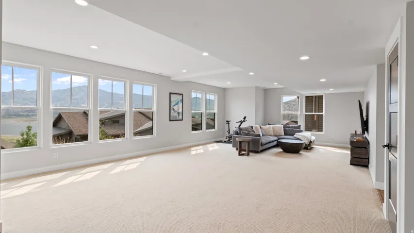 Spacious room with light-toned carpeting and recessed lighting