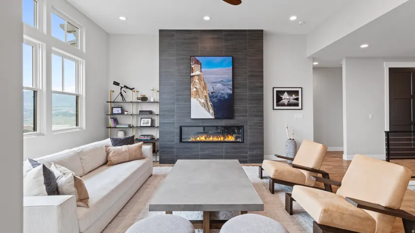 Living area featuring a floor-to-ceiling tiled fireplace, linear electric fireplace insert, and high transom windows