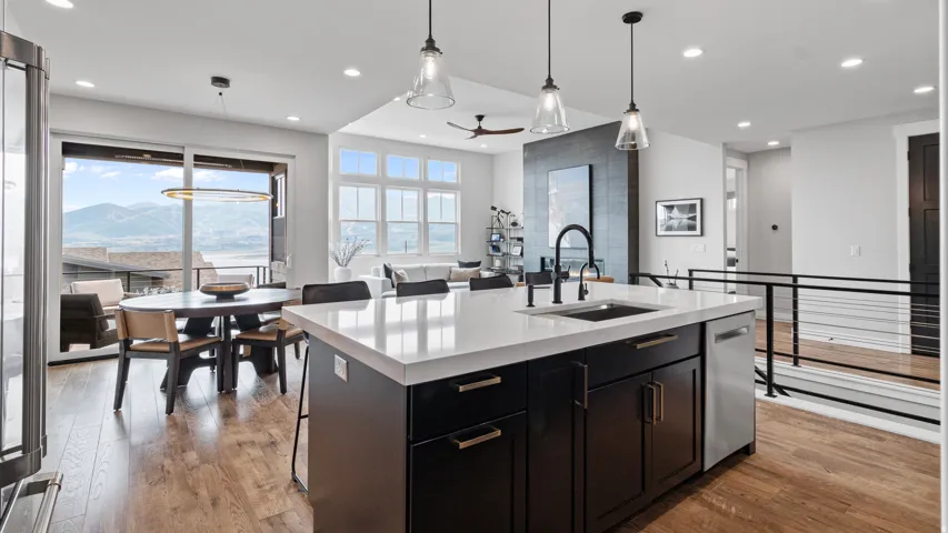Kitchen island featuring a white countertop, undermount sink, and black cabinetry