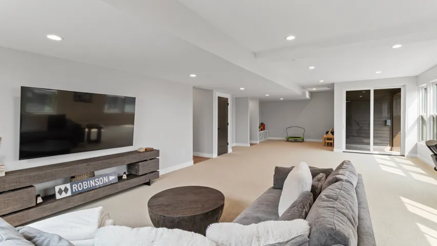 Spacious lower-level room featuring recessed lighting, light-toned carpeting, and light gray walls