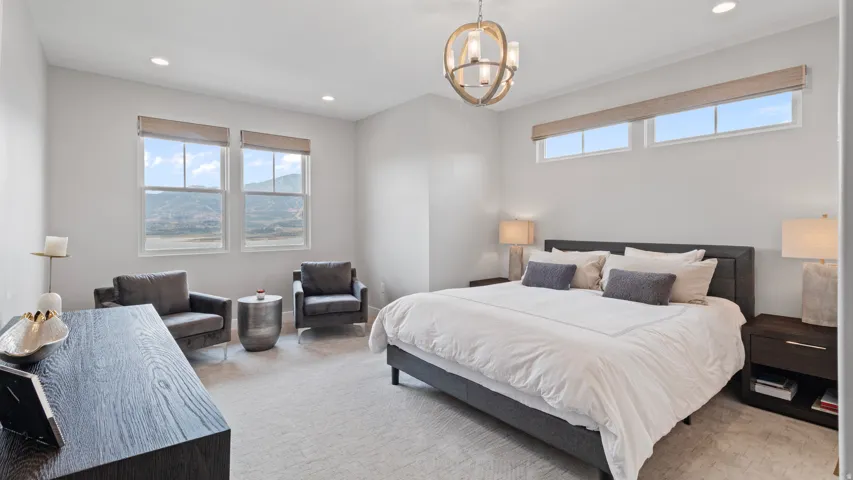 Spacious Primary Suite featuring carpeting, high ceilings with recessed lighting, and a contemporary chandelier