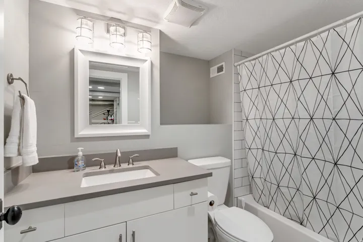 Modern bathroom featuring a contemporary vanity with a rectangular undermount sink, brushed nickel faucet, and a light gray countertop
