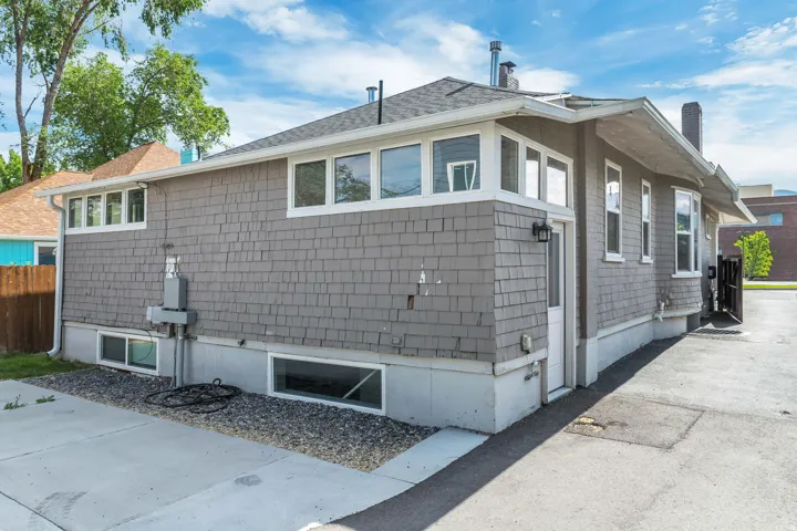 Exterior featuring shingle siding, a lower foundation, and multiple windows