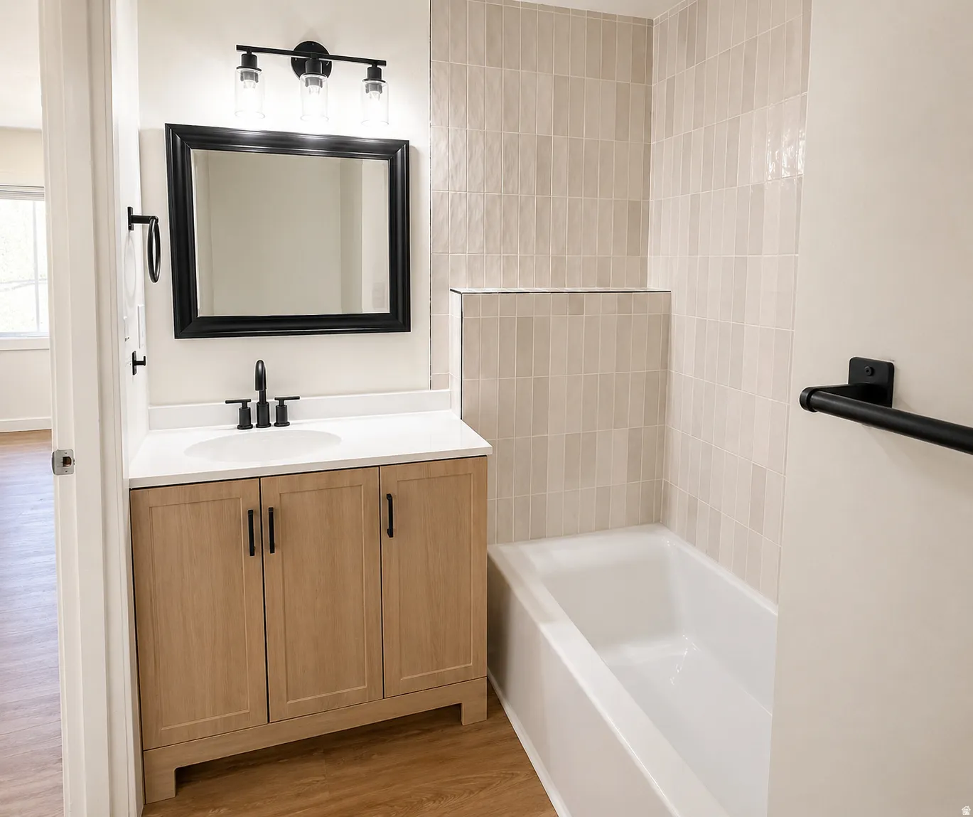 Bathroom featuring a white bathtub with light-toned rectangular wall tiling