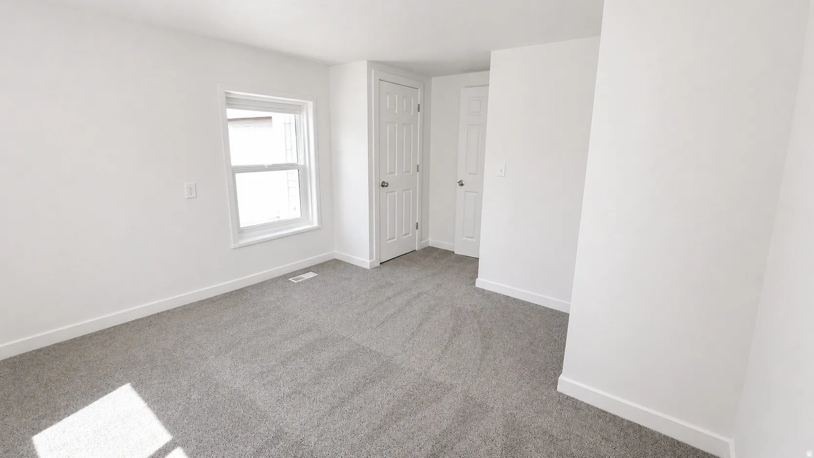 Room featuring light gray carpet, white painted walls, white trim, and a white framed window