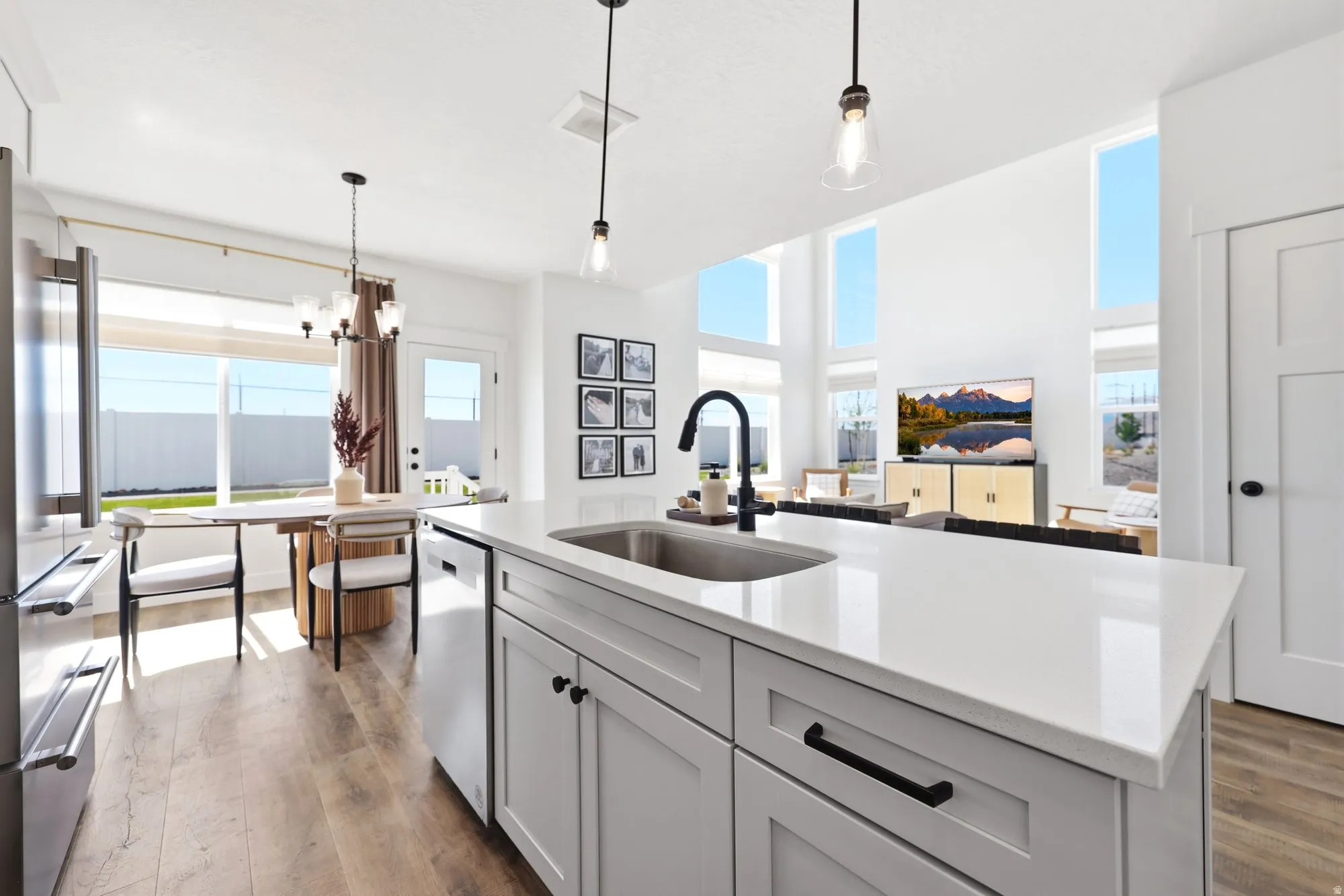 Kitchen island featuring a stainless steel sink, black faucet, and white countertop