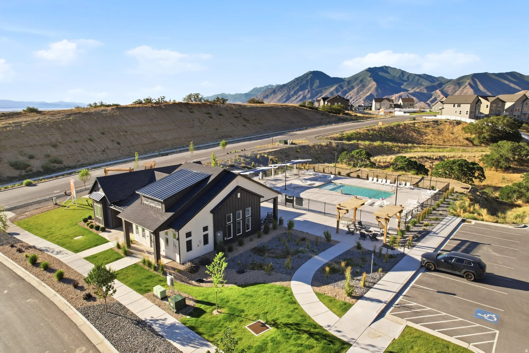 Modern-style community building featuring dark siding and light exterior finishes, solar panels, and a manicured lawn