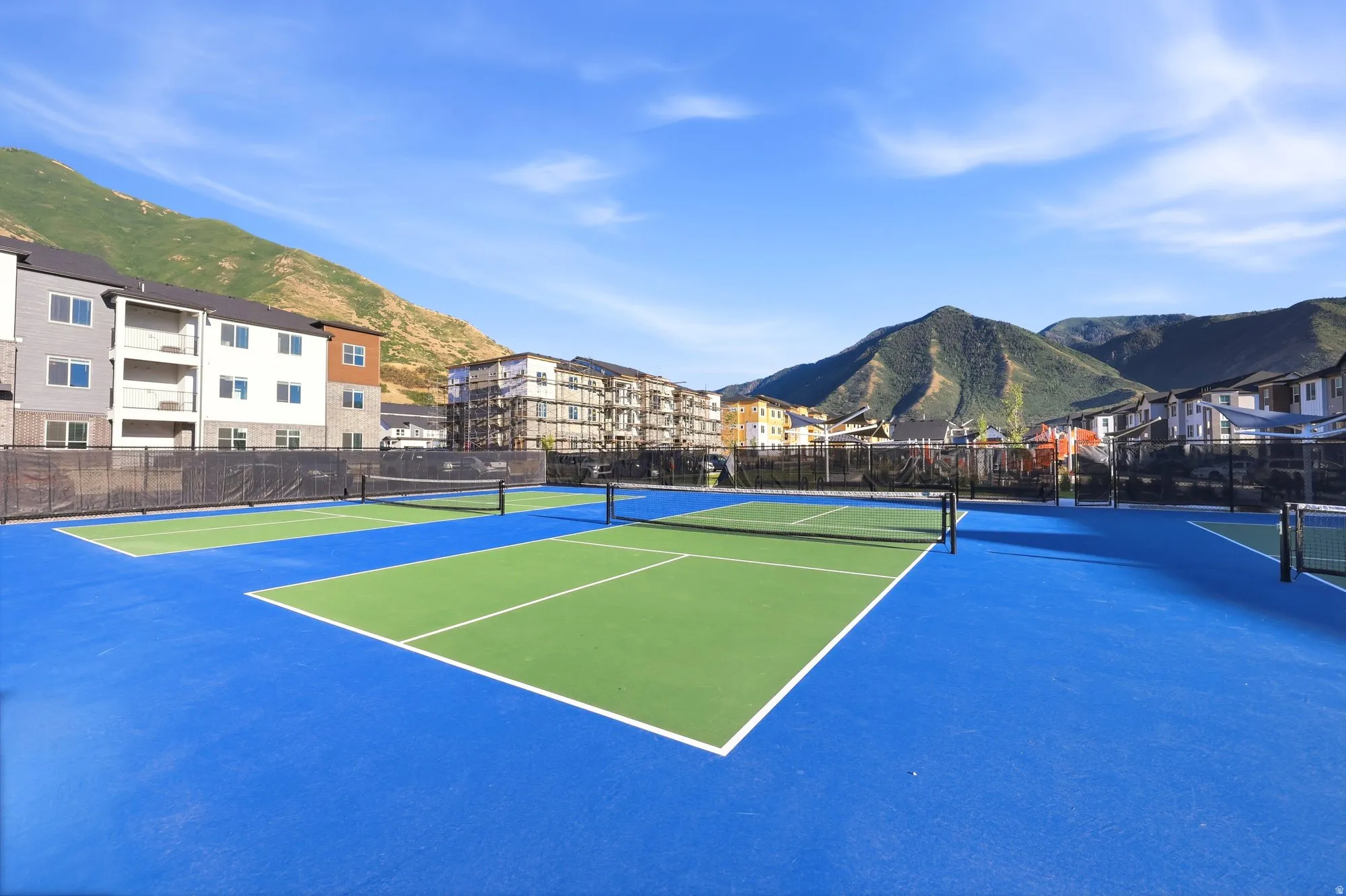Multiple tennis courts with blue and green surfacing