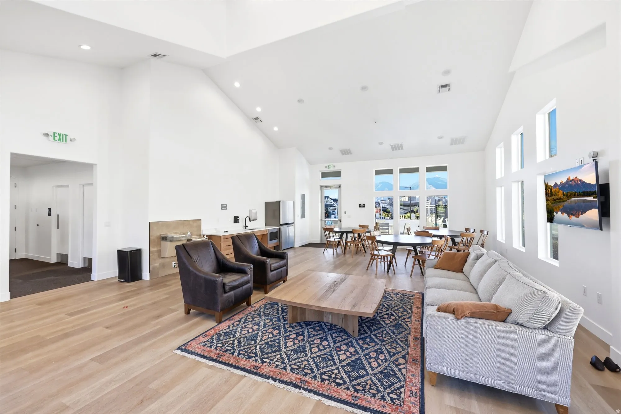 Spacious communal area featuring light wood-finish flooring, vaulted ceilings, and recessed lighting