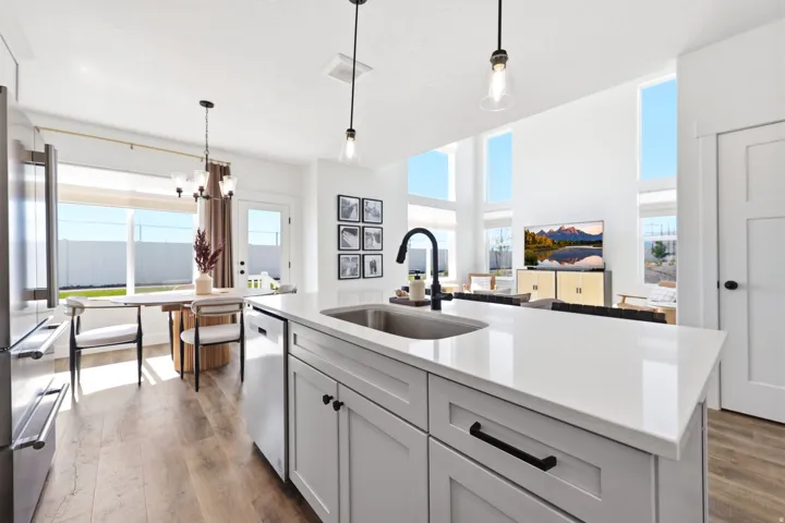 Kitchen island featuring a stainless steel sink, black faucet, and white countertop