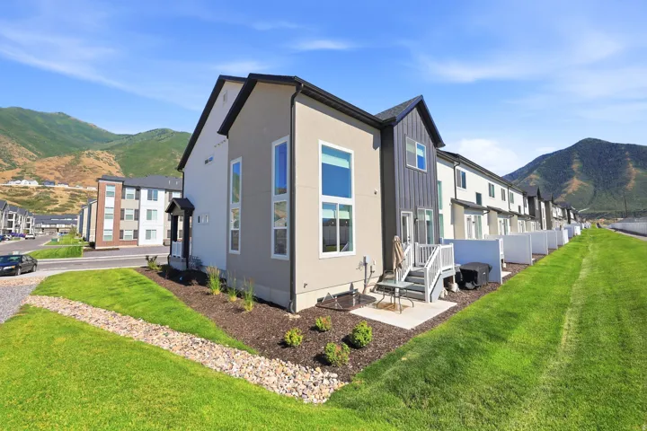 Modern townhome exterior featuring contemporary vertical siding accents and a contrasting stucco finish