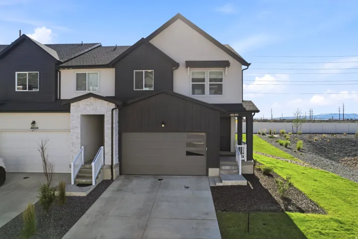 Contemporary multi-level exterior with a two-tone facade, featuring dark vertical siding and light stucco finishes