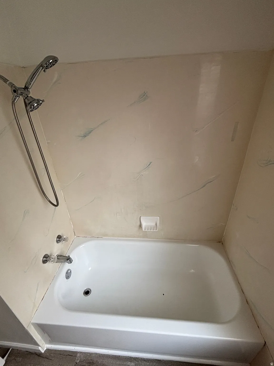 White bathtub with chrome fixtures and an integrated soap dish