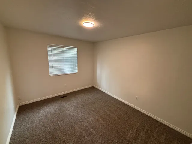 Neutral-toned walls complement the brown carpet flooring and white baseboards