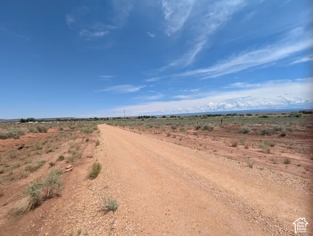 Gravel road extending through expansive terrain under a broad sky