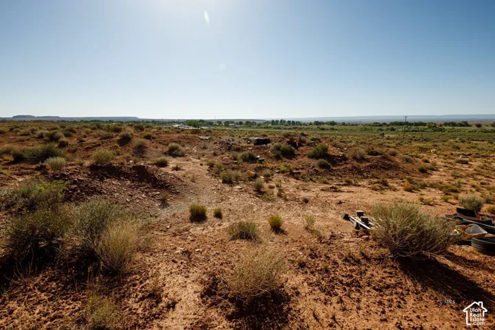 Expansive undeveloped land featuring natural terrain and distant vegetation