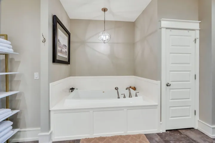 Soaking tub with white paneling and brushed nickel fixtures
