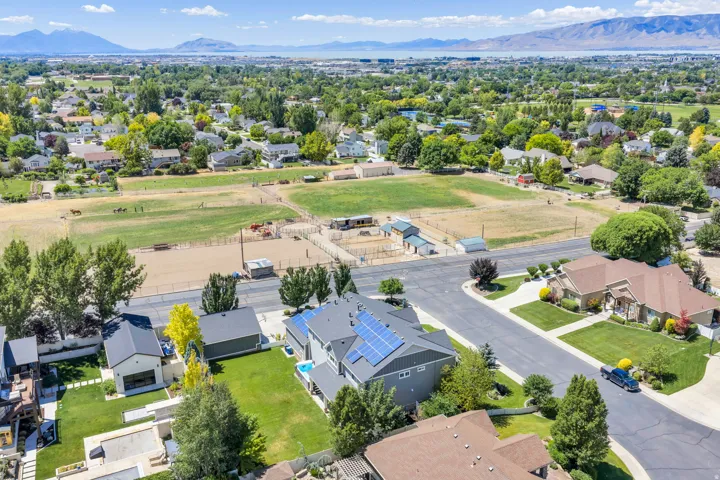 Aerial perspective showcasing a residential neighborhood with distant mountain ranges and a body of water