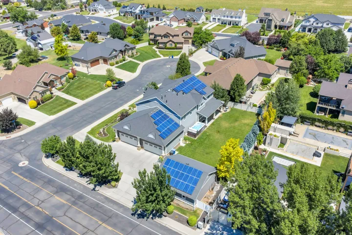 Residence featuring multiple solar panel arrays, a multi-level roofline, and a three-car garage