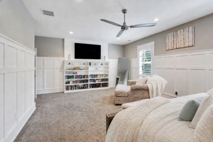 Spacious room featuring white wainscoting, recessed lighting, and a ceiling fan