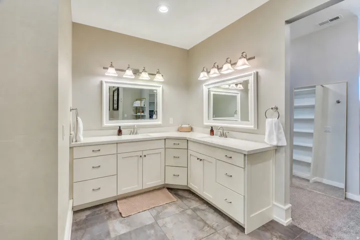 Dual vanity with white cabinetry and integrated sinks