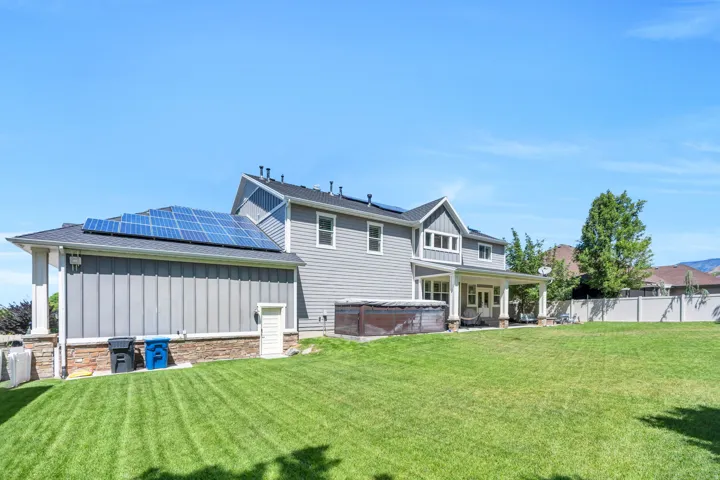 Expansive backyard featuring a manicured lawn, a covered patio, and a privacy fence