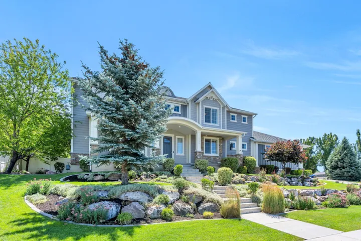 Contemporary residence featuring a light gray exterior with stone accents