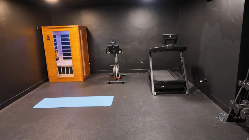 Dedicated fitness space featuring dark-toned walls and durable rubber flooring