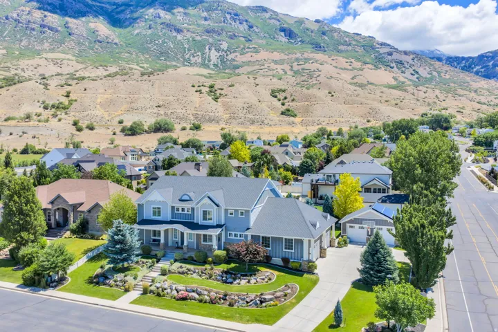 Expansive two-story residence with a light blue exterior siding and stone accents