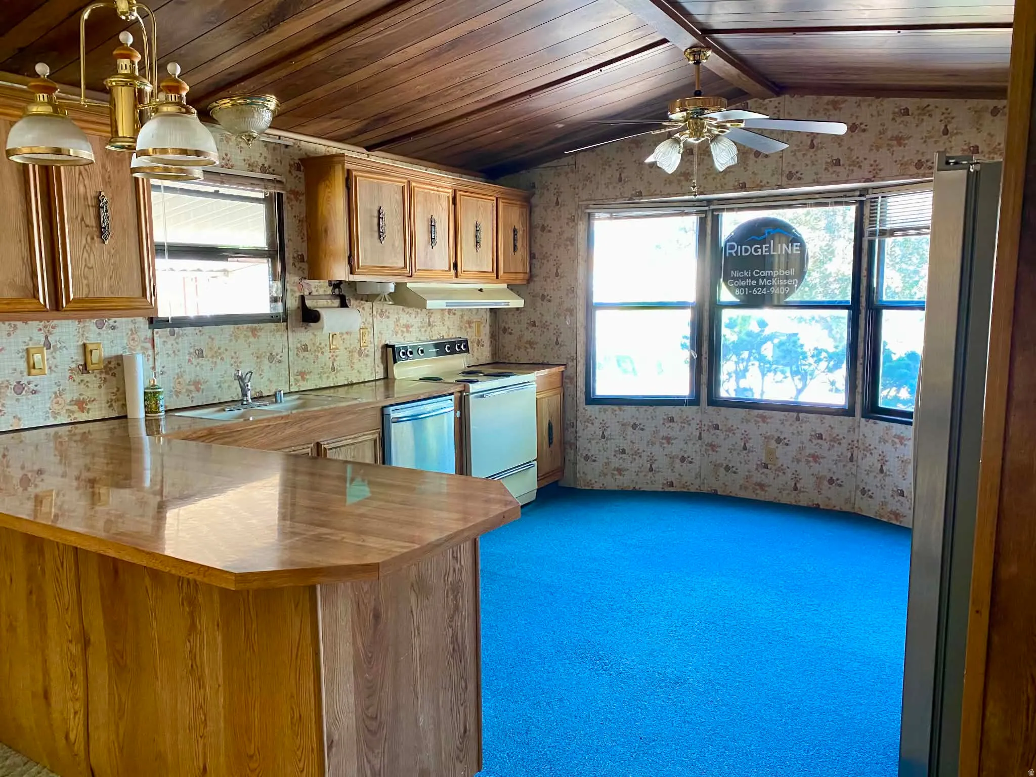 Kitchen featuring wood-finish cabinetry, built-in appliances, and a wood-finish peninsula with an extended countertop