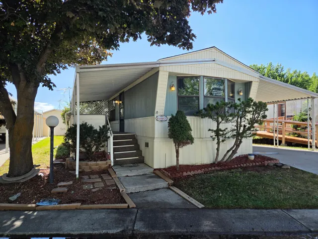 Light-colored siding exterior with a front entry porch featuring steps and a side ramp