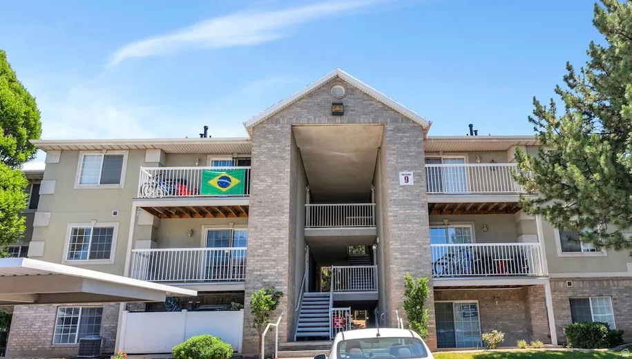 Multi-story building featuring light brick and stucco exterior