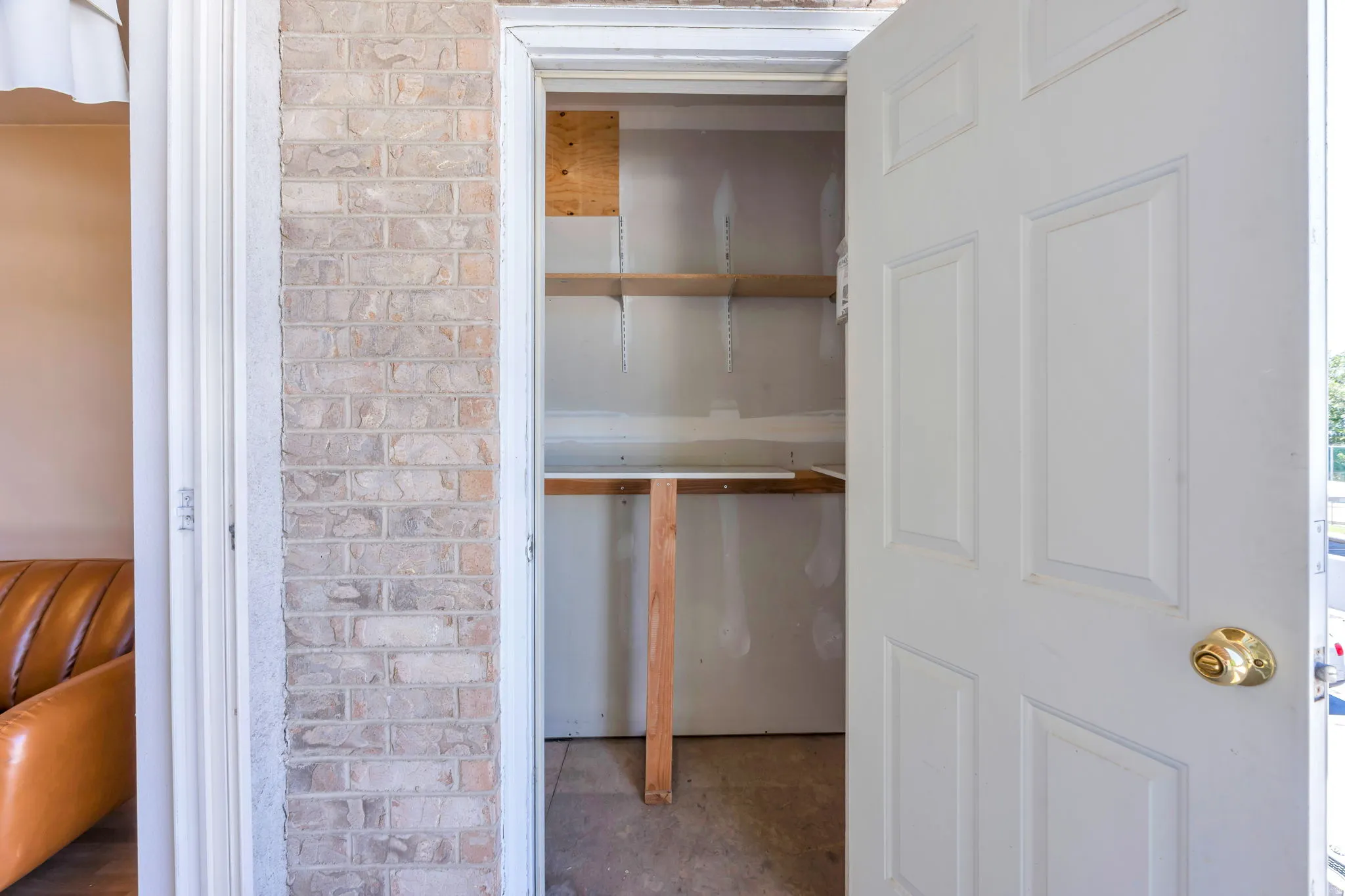 Storage area on Balcony  featuring built-in wood shelving