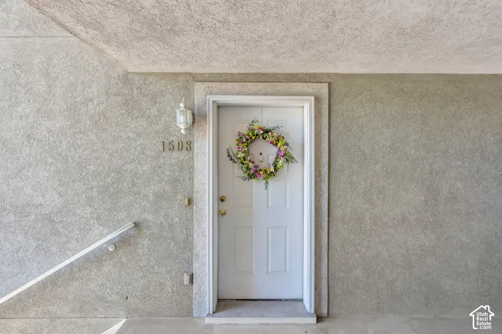 Up short flight of stairs. White paneled entry door with brass-finish hardware