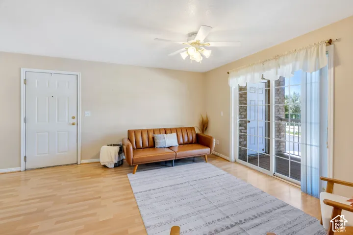 Open-concept living area with wood-finish flooring, Glass Doors out to Balcony.