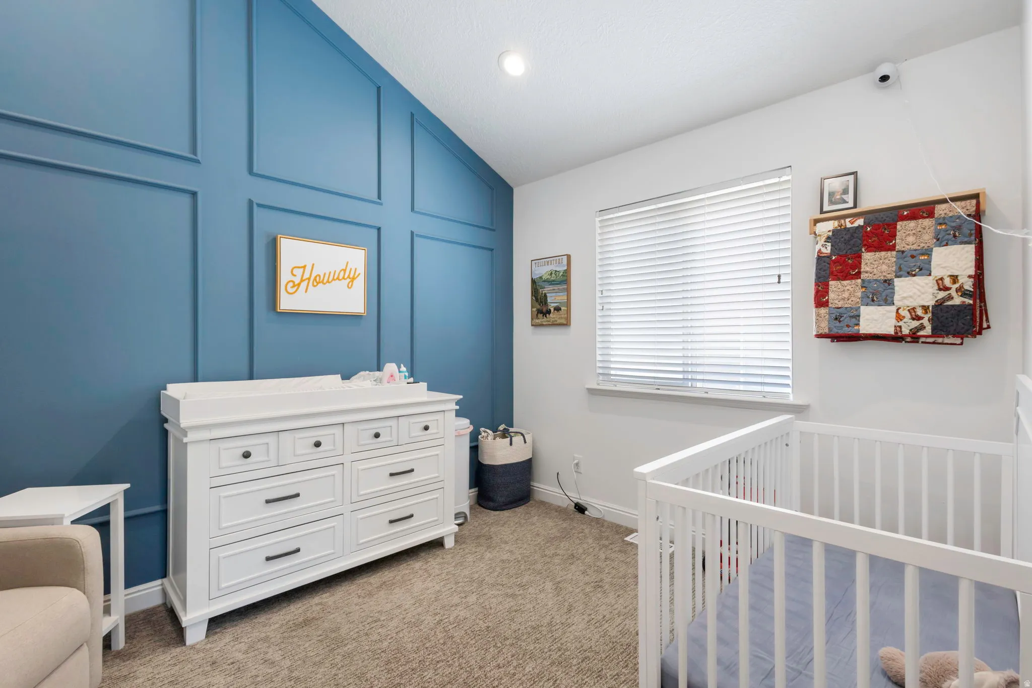 Accent wall featuring decorative paneling, vaulted ceiling, recessed lighting, carpet flooring, and a single window with blinds