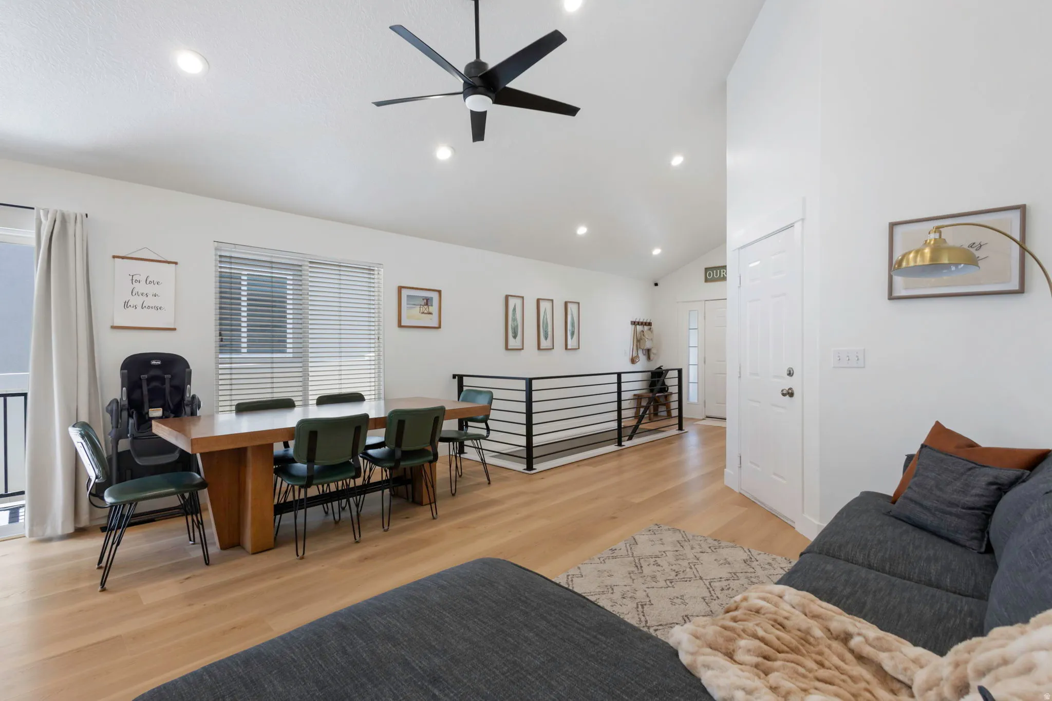 Open-concept living area featuring vaulted ceilings, recessed lighting, and wood-finish flooring