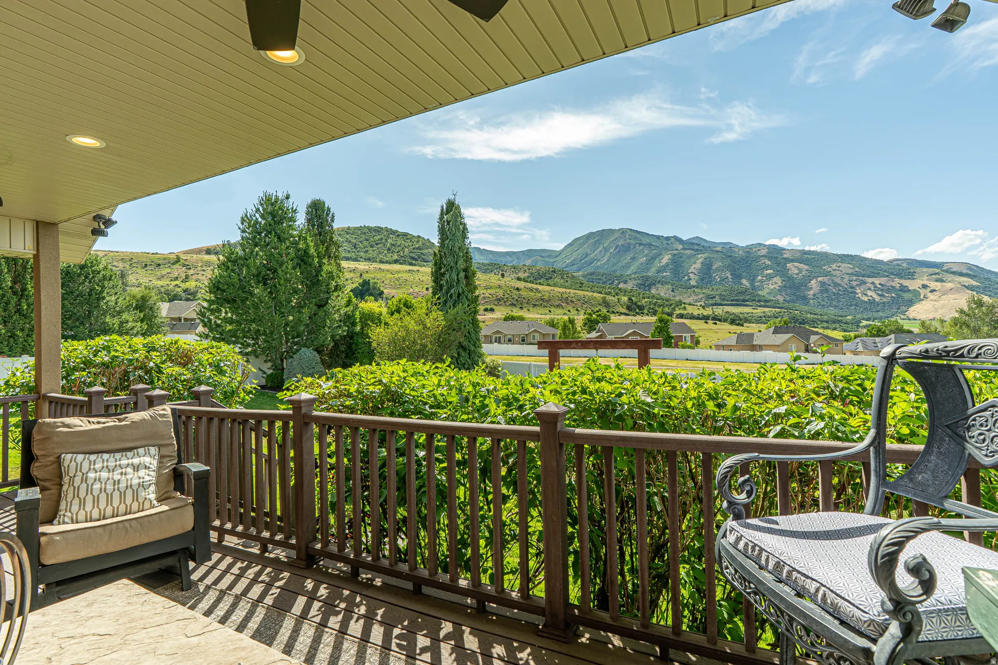 Covered outdoor patio with amazing mountain views, Trex deck, a ceiling fan with integrated lighting, and recessed ceiling lights