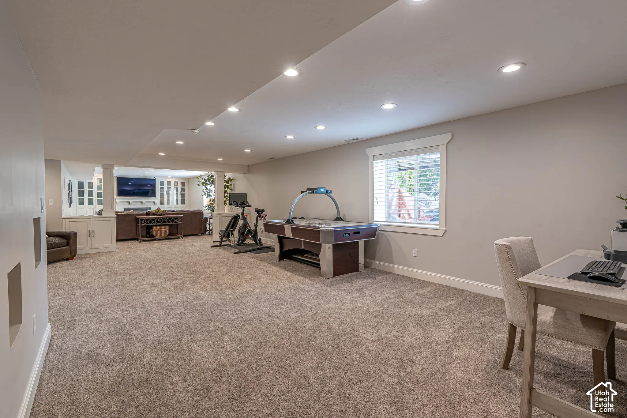 Spacious lower-level area featuring recessed lighting, new neutral carpeted floor, and a bright window with white blinds and trim