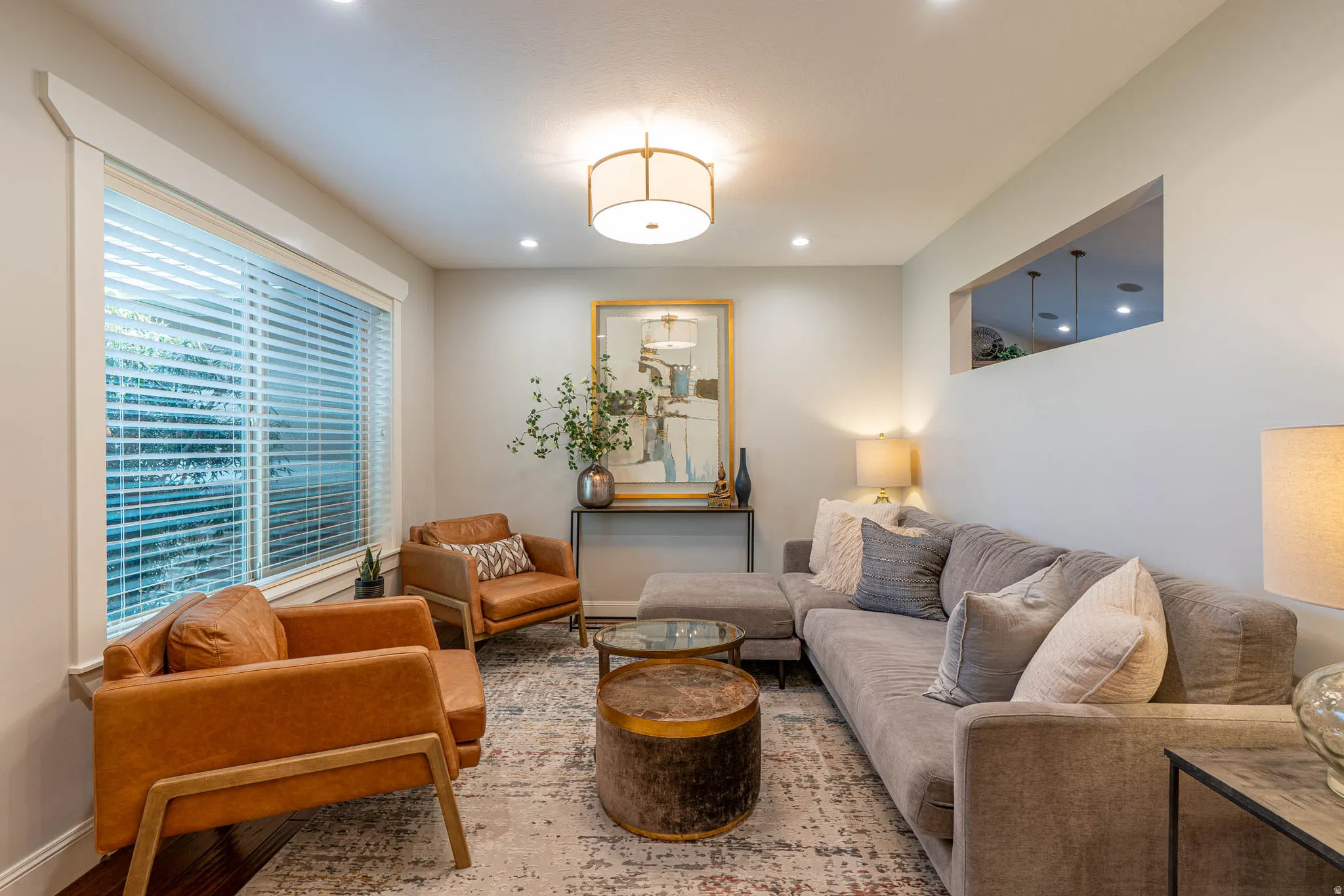 Living space featuring a large window with natural lighting, recessed lighting, and a drum-style ceiling fixture