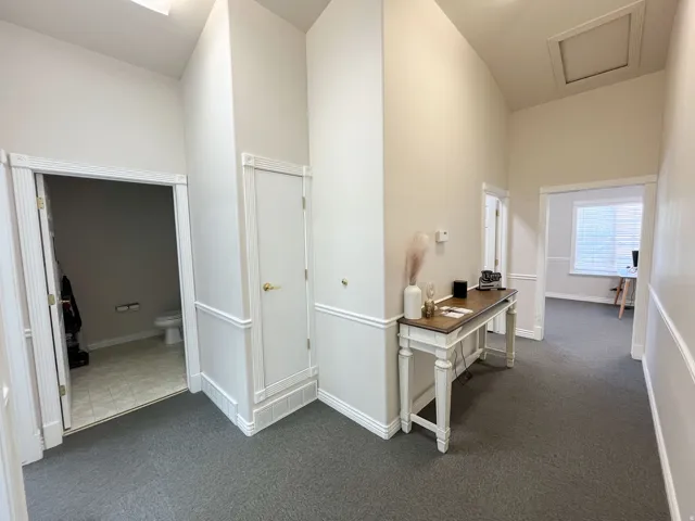 Central hallway with vaulted ceilings, recessed lighting, and wall paneling