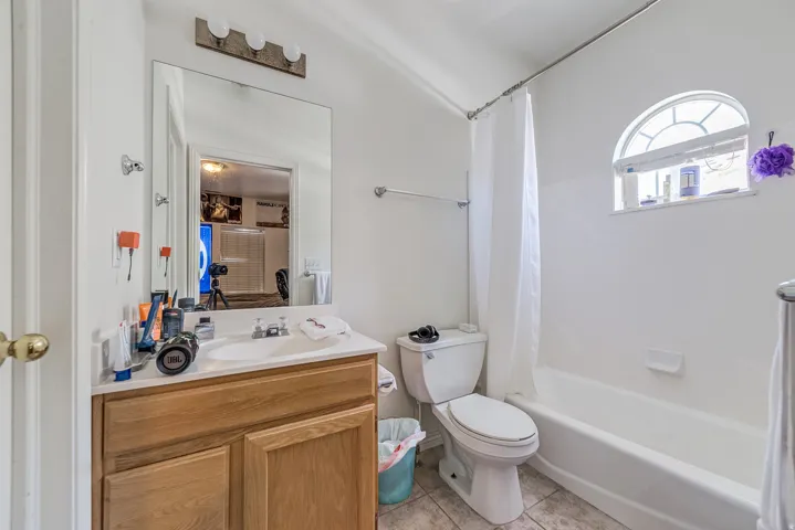 Bathroom featuring a wood-finish vanity with a white countertop and integrated sink